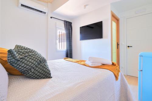 a bedroom with a bed with a tv on the wall at RG Duque de Aveiro in Málaga