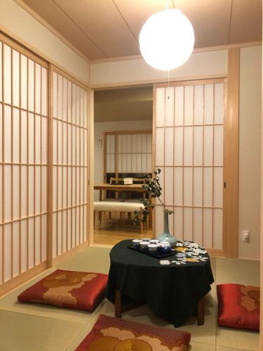 a room with a table in a room with white walls at 静雅の宿 in Kyoto