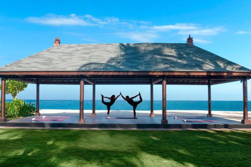 a gazebo with two sculptures of people on it at The St. Regis Bali Resort in Nusa Dua