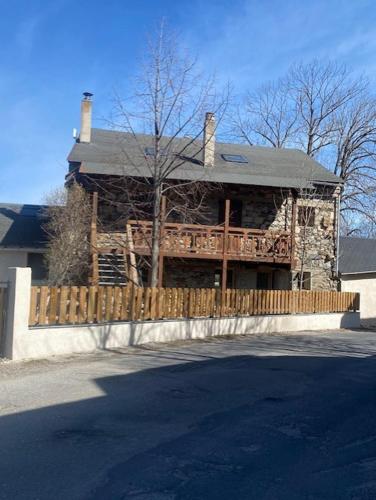 una casa con una valla de madera delante de ella en Appartement avec vue et jardin, en Formiguères