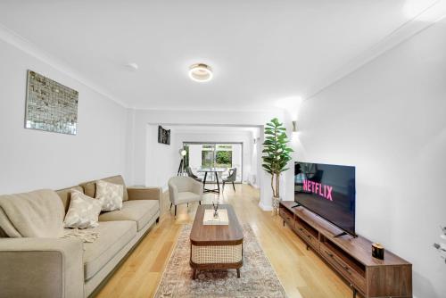 a living room with a couch and a tv at Lux 5 Bed sleeps 11, 10 mins from Wembley Stadium, Jacuzzi and Steam Shower in Harrow on the Hill