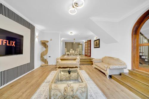 a living room with a couch and a tv at Lux 5 Bed sleeps 11, 10 mins from Wembley Stadium, Jacuzzi and Steam Shower in Harrow on the Hill