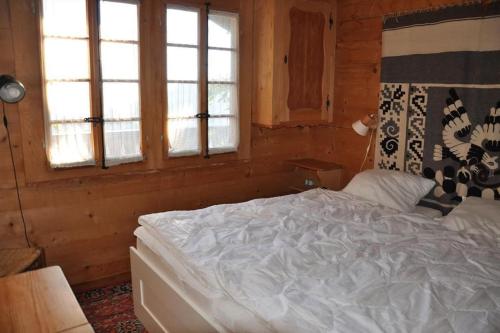 - une chambre avec un lit blanc et 2 fenêtres dans l'établissement Fleur des Champs, à Gryon