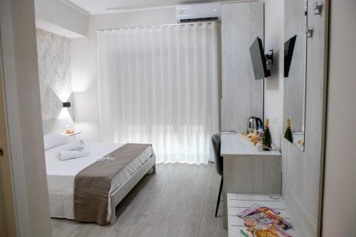 a bedroom with a bed and a desk with a television at Bed and Breakfast 3 Medaglie in Rende