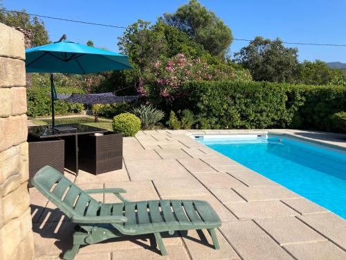 une chaise verte et un parasol à côté de la piscine dans l'établissement Studio avec piscine Ruppione, à Pietrosella