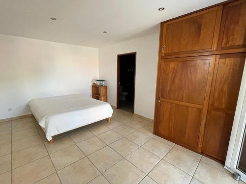 a bedroom with a bed and a large wooden closet at Kaz Mont Vert in Saint-Pierre