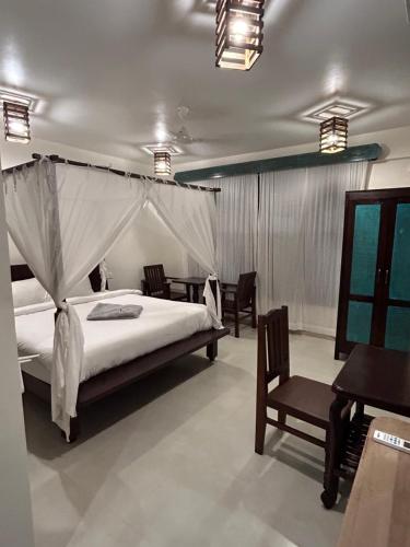 a bedroom with a bed and chairs in a room at Shivam bnb Boutique Apartments in Mandrem