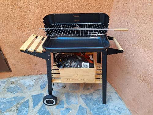 a charcoal grill sitting next to a wall at La Caseta del Piro in Gratallops