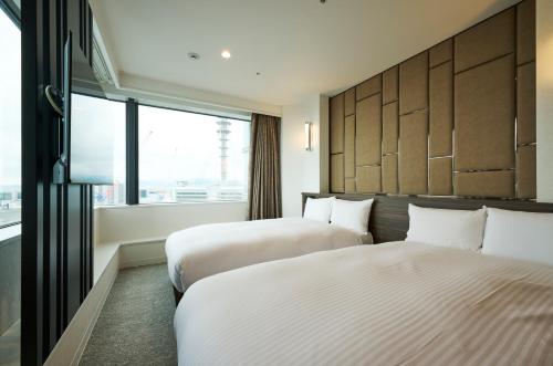 Postel nebo postele na pokoji v ubytování HOTEL FUKURACIA OSAKA-BAY