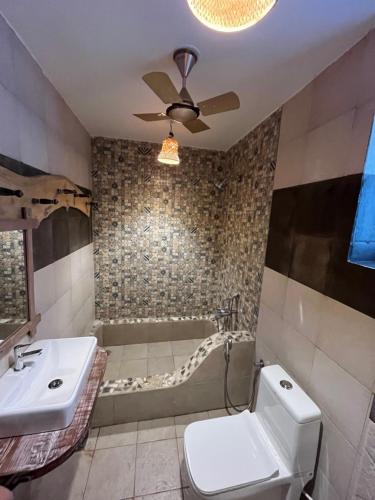 a bathroom with a tub and a toilet and a sink at Shivam bnb Boutique Apartments in Mandrem