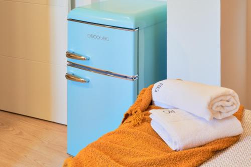 a refrigerator with towels on a blanket next to it at RG Duque de Aveiro in Málaga