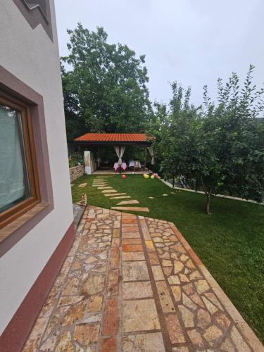 a garden with a stone walkway next to a building at Villa Sara in Kratovo