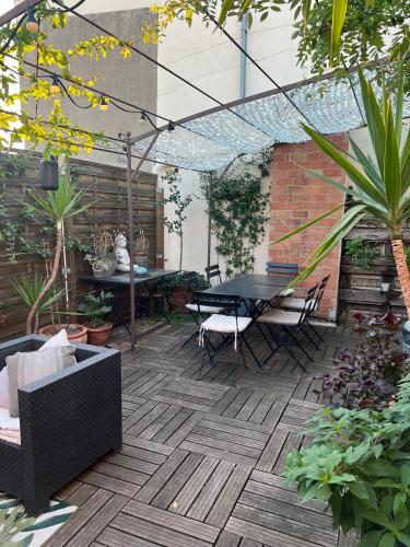 un patio avec une table, des chaises et des plantes dans l'établissement Chambre indépendante avec SDB-Terrasse privative. Centre ville, à Nîmes