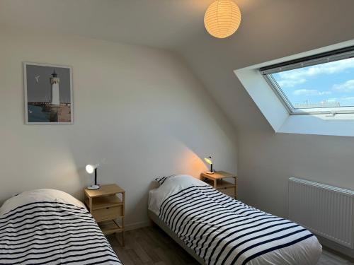 - 2 lits dans une chambre avec un phare dans l'établissement Maison au calme, proche plage, wifi, jardin clos, à Quiberon