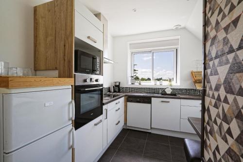 une cuisine avec des appareils électroménagers blancs et une fenêtre dans l'établissement TyNoLa, à Ploudaniel