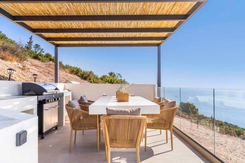 a kitchen and dining room with a table and chairs at Infinity Luxury Villas, Lefkada in Athanion