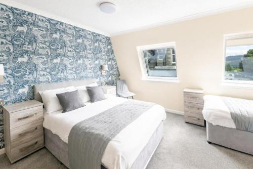 a bedroom with two beds and a wall mural at Loch Ness Drumnadrochit Hotel in Drumnadrochit