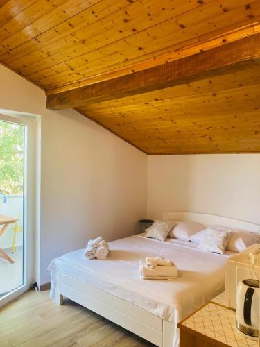 a bedroom with two beds and a wooden ceiling at Apartment Mrkić in Biograd na Moru