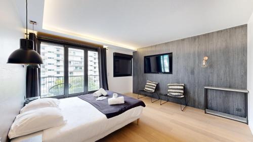 une chambre avec un grand lit et une grande fenêtre dans l'établissement Bluestay 55 - Charmant appartement à Paris, à Paris