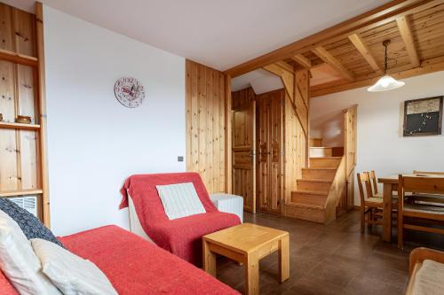 un salon avec un canapé rouge et une table dans l'établissement Duplex en centre station des Coches - Ménage et linge de maison inclus, à La Plagne Tarentaise