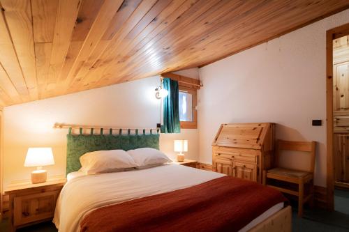 - une chambre avec un grand lit et un plafond en bois dans l'établissement Duplex en centre station des Coches - Ménage et linge de maison inclus, à La Plagne Tarentaise