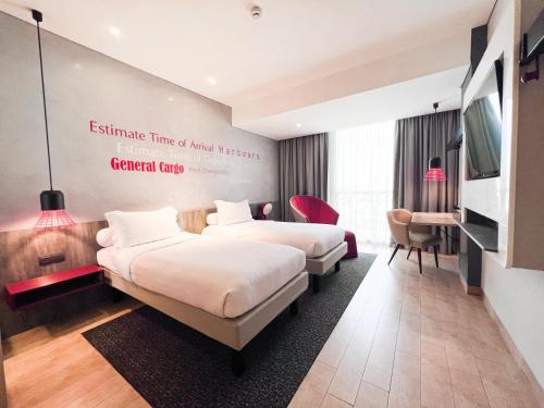 a hotel room with two beds and a flat screen tv at ibis Styles Batam Nagoya in Nagoya