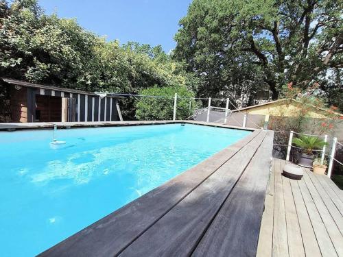 - une piscine avec une terrasse en bois et de l'eau bleue dans l'établissement FREJUS-Villa indépendante piscine et jaccuzzi, à Fréjus