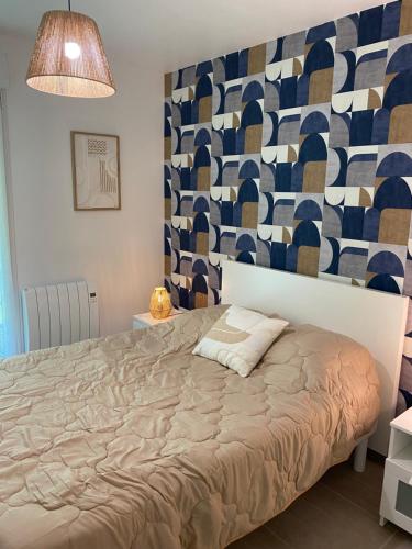 1 dormitorio con 1 cama y una pared colorida en Appartement proche plage et CNPE, en Gravelines