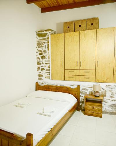 a room with a bed and wooden cabinets at Guest house Dimitra in Sitia