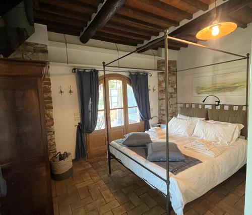 a bedroom with a bed with a metal canopy at Olimagio Farm Stay with animals and 25m pool, beach at cycling distance in Pietrasanta