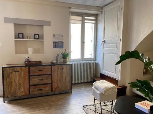 un soggiorno con cassettiera in legno e finestra di Maison de ville-idéale pour les déplacements pros-35min Paris-versailles-Giverny- a La Falaise