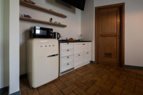 a kitchen with a refrigerator with a microwave on top at Olimagio Farm Stay with animals and 25m pool, beach at cycling distance in Pietrasanta