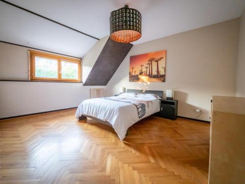 une chambre avec un lit et un lustre dans l'établissement Jolie Villa avec jardin, à Grigny
