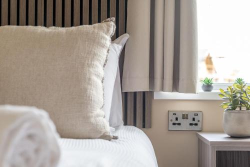 a bed with a white pillow and a window at Eden View Estate - Eden Lodge in St. Andrews
