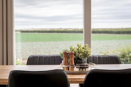 a dining room table with chairs and a large window at Eden View Estate - Eden Lodge in St. Andrews