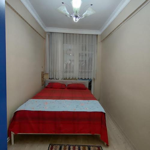 a bedroom with a red bed and a chandelier at Nur home1 in Istanbul