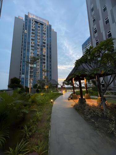 a walking path in a city with tall buildings at Spacious 2 King Bed Family Room 56 Sqm PODOMORO APARTMENT Tower Liberty 21st Floor with Mall Direct Access in Medan