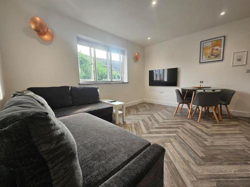 a living room with a couch and a table at Apollo 16-1 bed town center in Luton