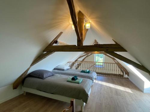 a bedroom with two beds in the attic at Ecuries Tourangelles in Bréhémont