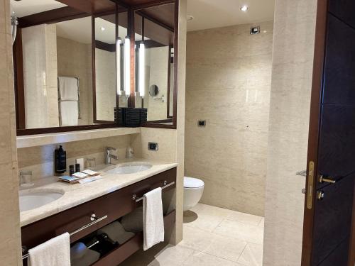 a bathroom with two sinks and a toilet at Smy Carlos V Wellness & Spa Alghero in Alghero