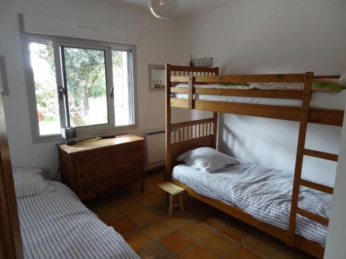 une chambre avec deux lits superposés et une fenêtre dans l'établissement Villa TAKY - LE VERDON SUR MER - max 11 pers, au Le Verdon-sur-Mer