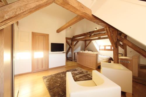 a large room with wooden ceilings and a bedroom at Hotel Historia Malomkert in Veszprém
