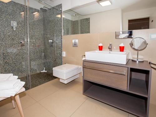 a bathroom with a sink and a shower at DORMERO Strandapartments Rügen in Binz
