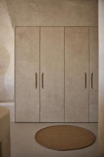 a white cabinet with four doors and a rug at One of One Hotel in Imerovigli