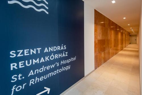 a hallway with a sign on the wall of a building at Hunguest Hotel Panoráma in Hévíz