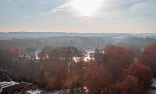 a view of a city with trees and the sun at Hunguest Hotel Panoráma in Hévíz