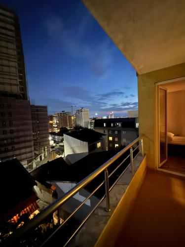 een balkon met uitzicht op de stad 's nachts bij Park Street Apartments in Pristina