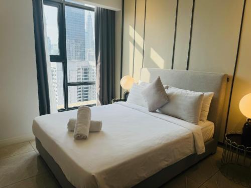 a bedroom with a white bed with a large window at AXON Residences Kuala Lumpur in Kuala Lumpur