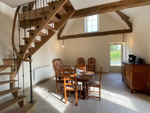 une salle à manger avec une table en bois et un escalier en colimaçon dans l'établissement Ecuries Tourangelles, à Bréhémont