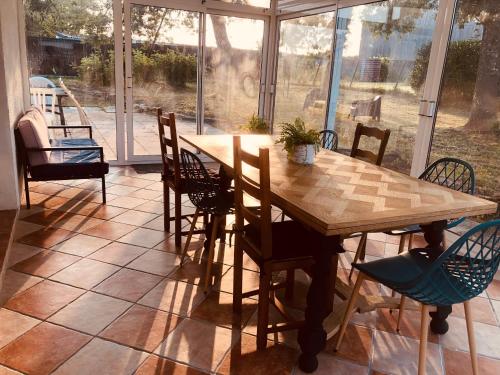 - une table et des chaises en bois dans une chambre avec fenêtre dans l'établissement Maison de campagne proche de la côte, à Chauvé